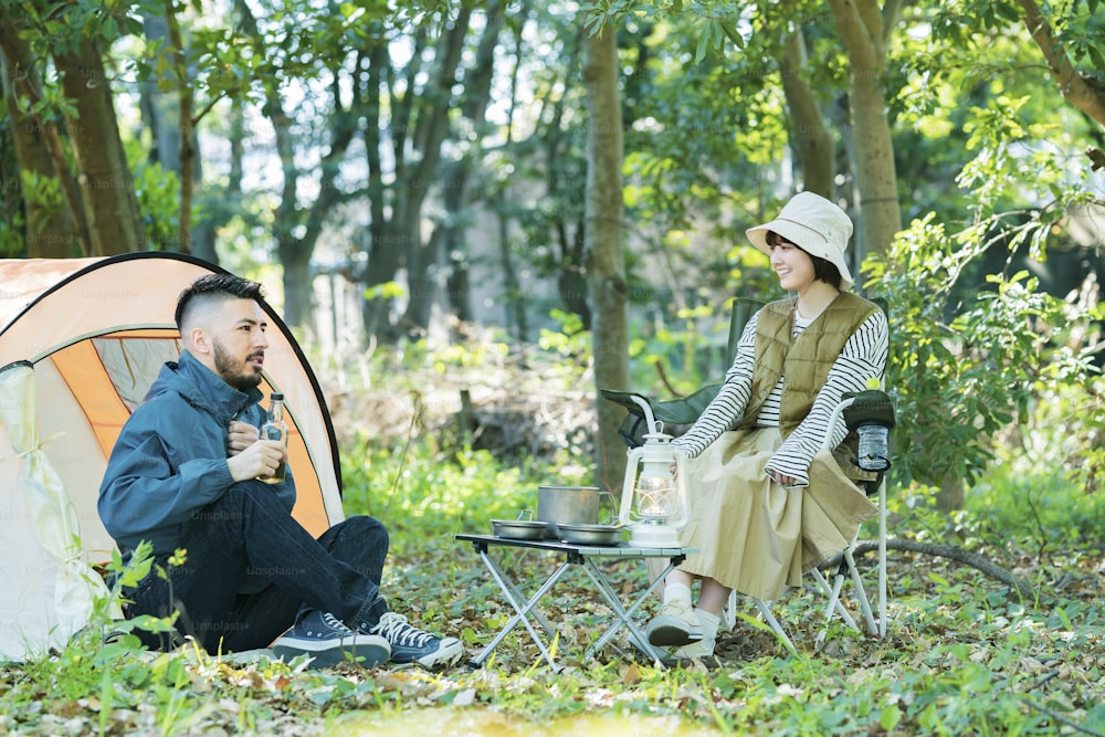 Man and woman enjoying camping in the forest