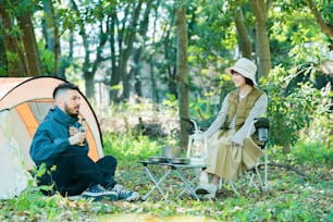 Man and woman enjoying camping in the forest