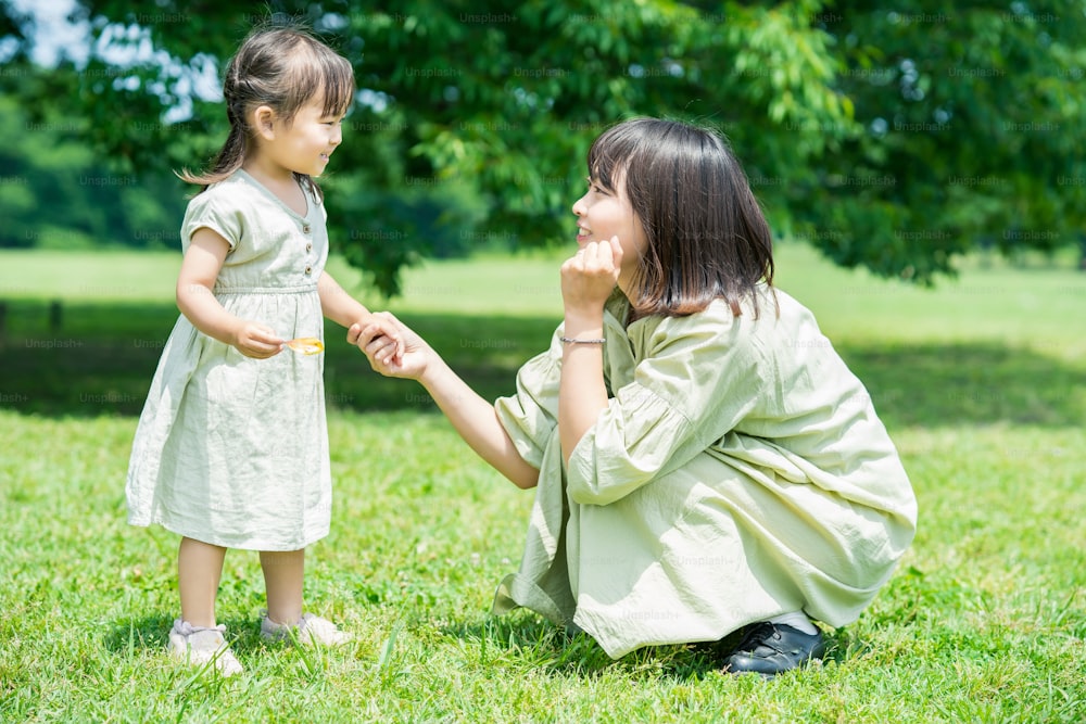 Une mère asiatique et sa fille jouent dans le parc