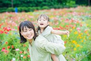 Madre y su hija paseando por el campo de flores en el parque