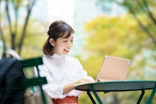 Female using a tablet PC at the table in the street