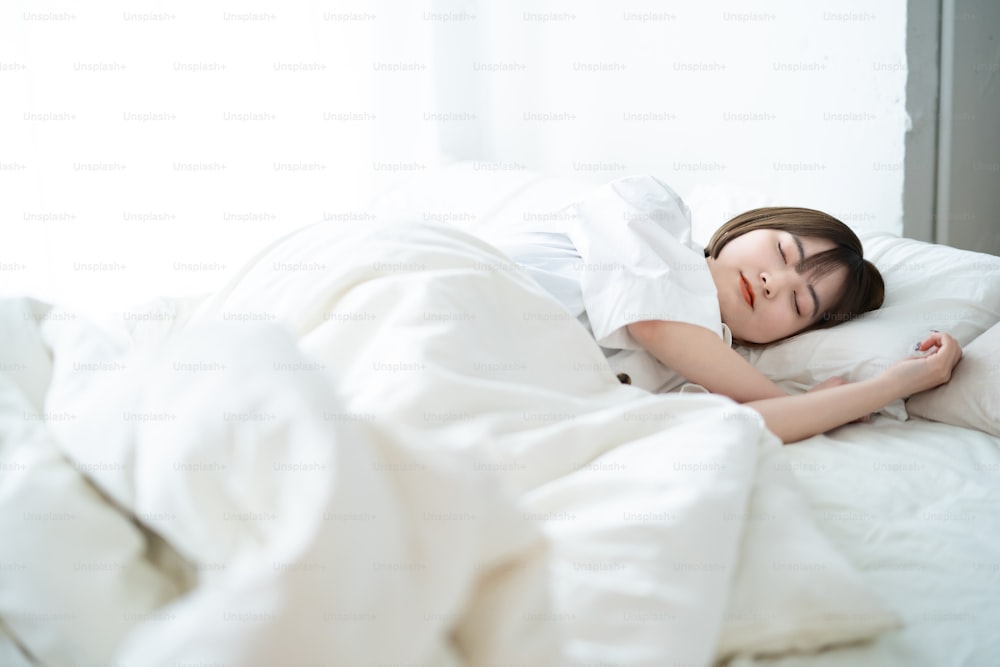 Female sleeping on a bed in a bright room