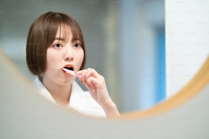 Young woman brushing teeth in the washroom