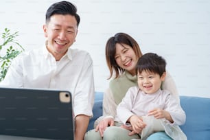 Family looking at the screen of a tablet PC indoors