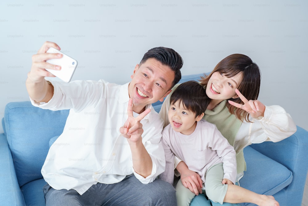 Parents and child taking selfies with their smartphones