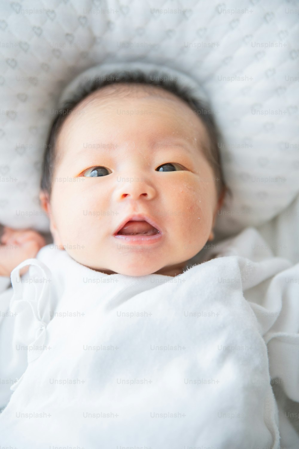 Nouveau-né asiatique (japonais) bébé au lit (0 ans 0 mois)