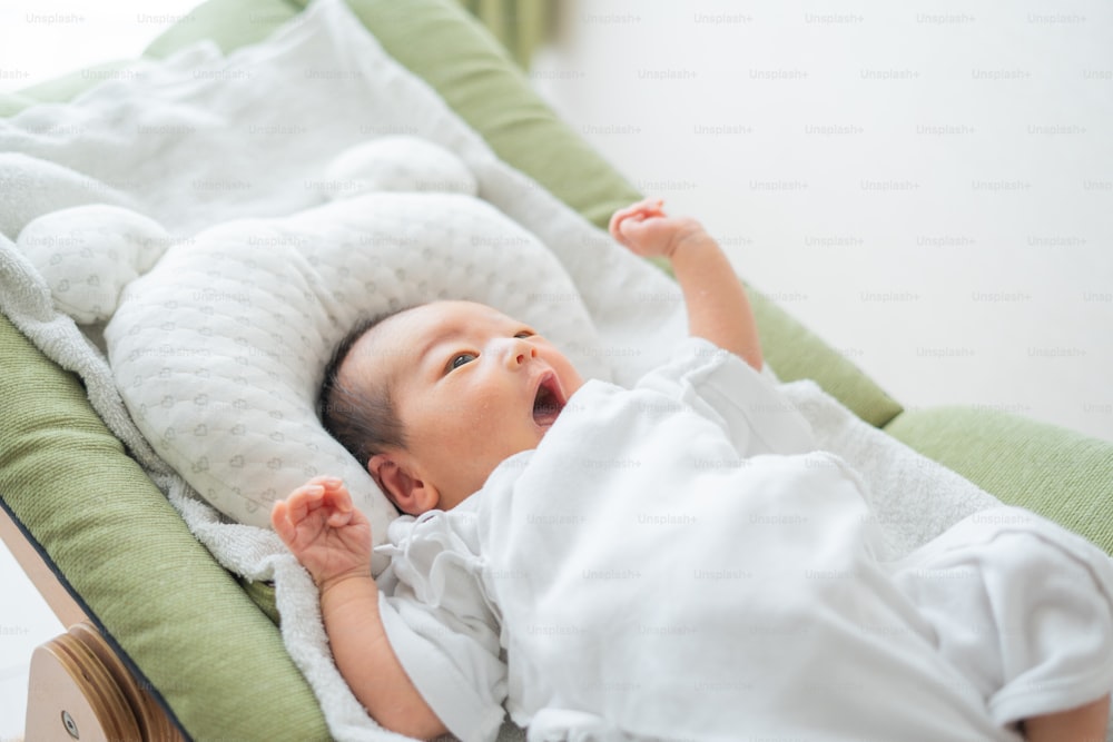 Newborn Asian (Japanese) baby on bed (0 years 0 months old)