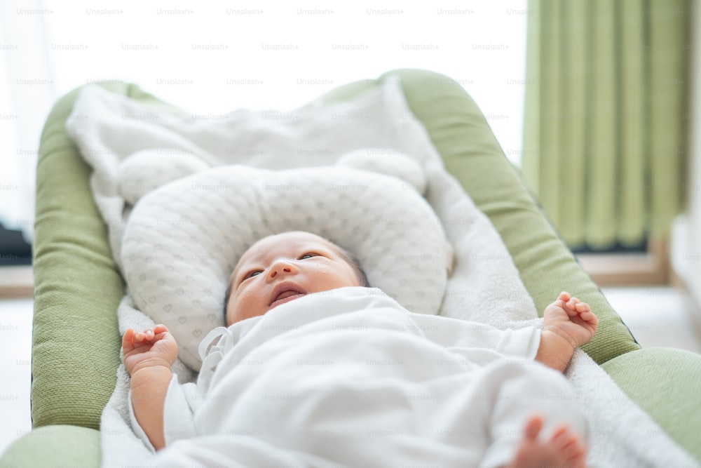 Nouveau-né asiatique (japonais) bébé au lit (0 ans 0 mois)