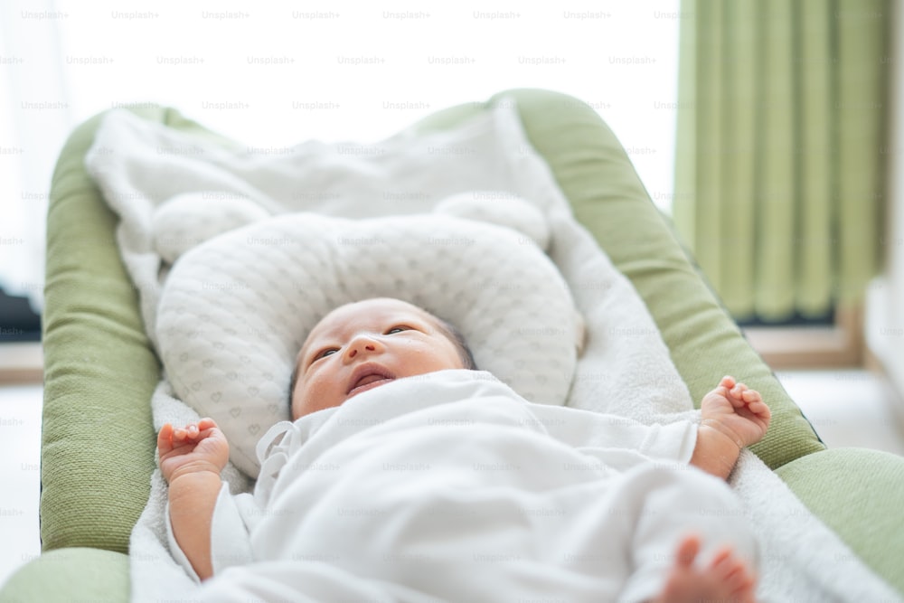 Newborn Asian (Japanese) baby on bed (0 years 0 months old)