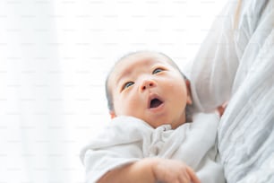アジア人(日本人)の新生児(0歳0ヶ月)を抱く母親