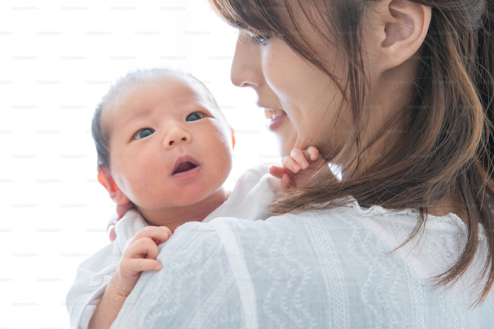 Une mère portant un nouveau-né asiatique (japonais) (0 an 0 mois)