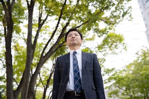 Portrait d’un homme d’affaires asiatique (japonais) dans une rue d’affaires à Tokyo, Japon