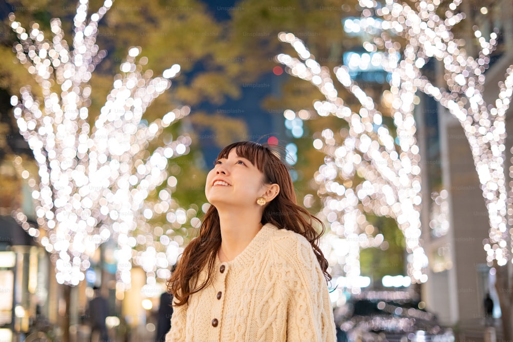 An Asian (Japanese) young woman watching the illuminations that color the night city