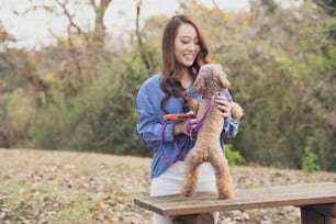 Young Asian woman walking in the park with her pet