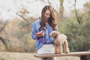 애완 동물과 함께 공원을 걷는 젊은 아시아 여성
