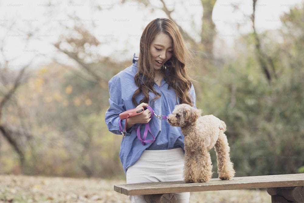 애완 동물과 함께 공원을 걷는 젊은 아시아 여성