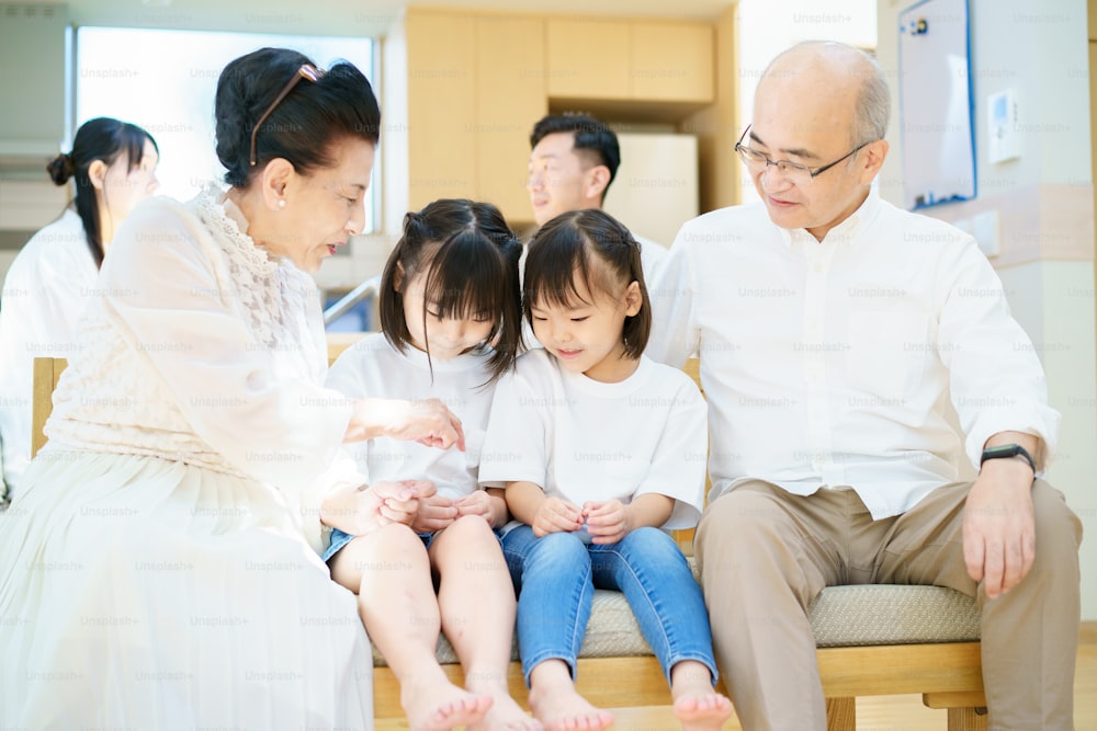 2 kleine Enkeltöchter sprechen mit Großeltern im Zimmer
