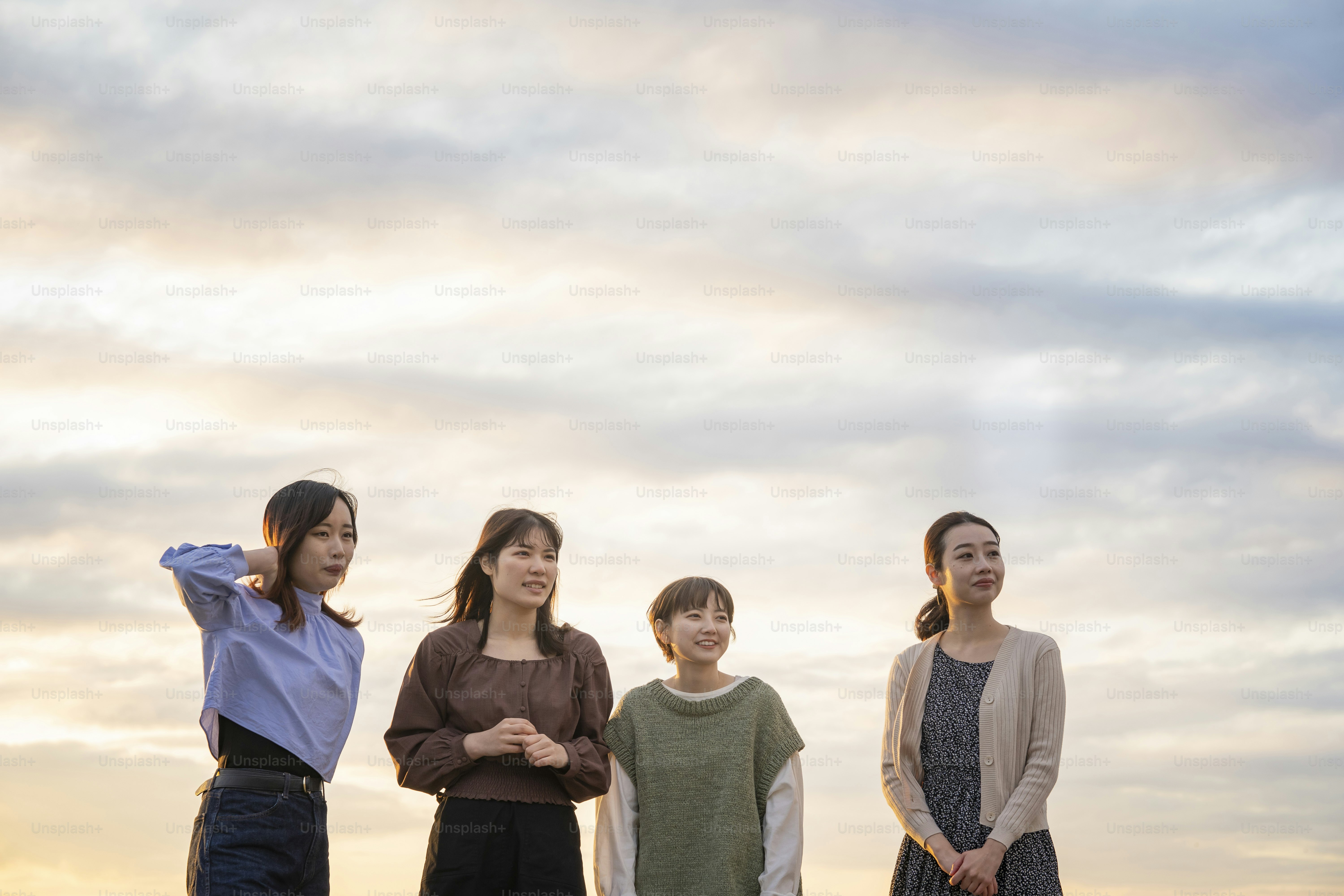 4 young asian women looking at the distant scenery in evening