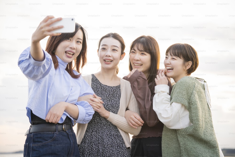 4 young women taking a commemorative photo with a smartphone