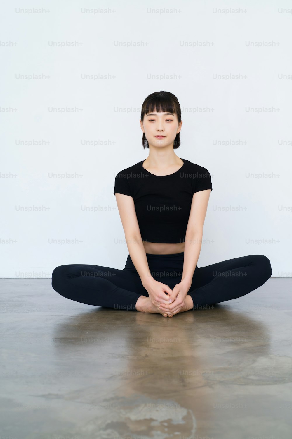 Uma mulher que faz yoga em uma única pose dentro de casa