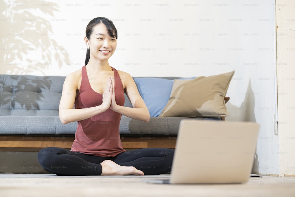 A woman doing yoga while looking at the computer screen in the room