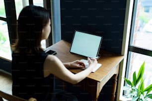 Uma mulher que se comunica on-line usando um tablet PC na sala