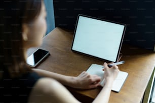 Una mujer que se comunica en línea usando una tableta en la habitación