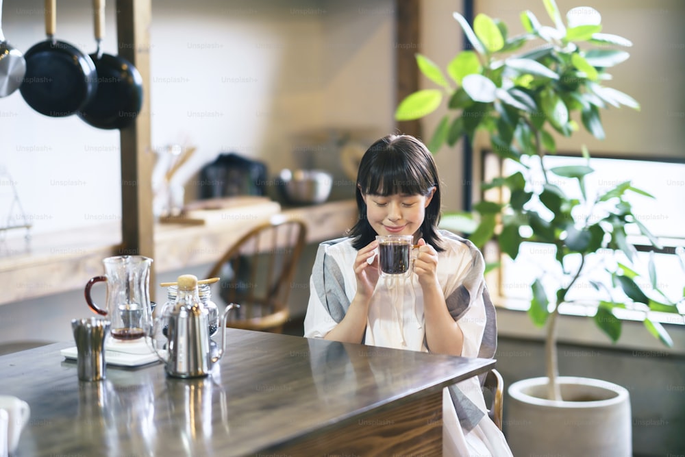 A young woman brewing and drinking coffee in a calm atmosphere