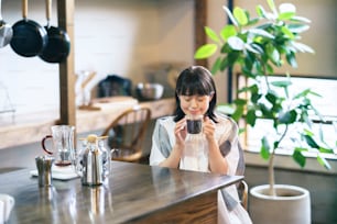 A young woman brewing and drinking coffee in a calm atmosphere
