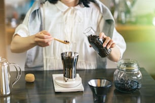 A young woman brewing coffee in a relaxing space