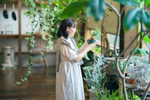 Una mujer joven mirando las plantas de follaje con una sonrisa