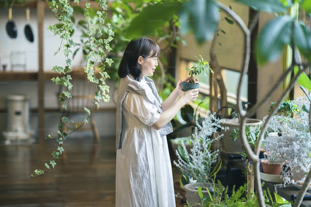 Una giovane donna che guarda le piante del fogliame con un sorriso