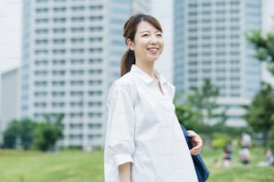 Asian woman wearing a white shirt and taking a walk in a relaxing atmosphere