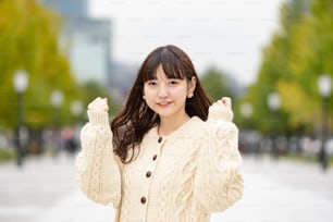 Asian (Japanese) young woman doing a guts pose and cheering with a smile
