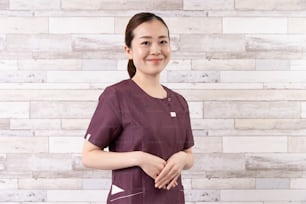 Asian young female practitioner dressed in reddish brown clothes at a beauty salon store