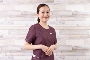 美容院の店で赤茶色の�服を着たアジアの若い女性開業医