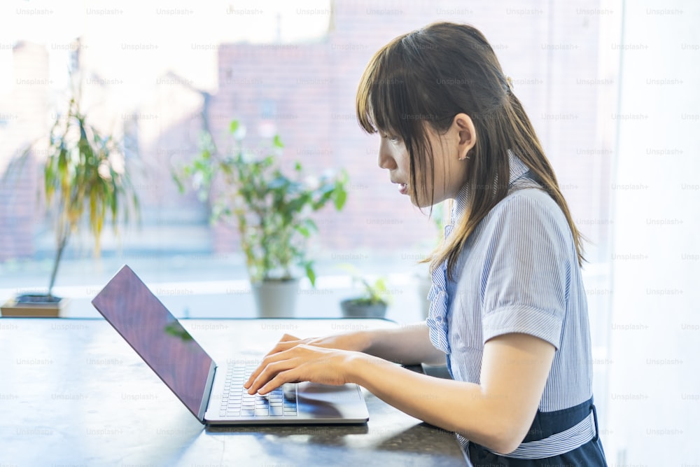 Asian woman doing desk work in the living room at home