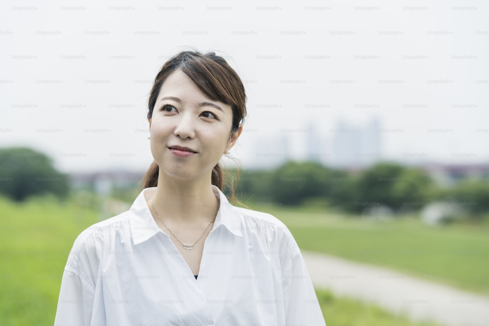 Asian woman wearing a white shirt and taking a walk in a relaxing atmosphere