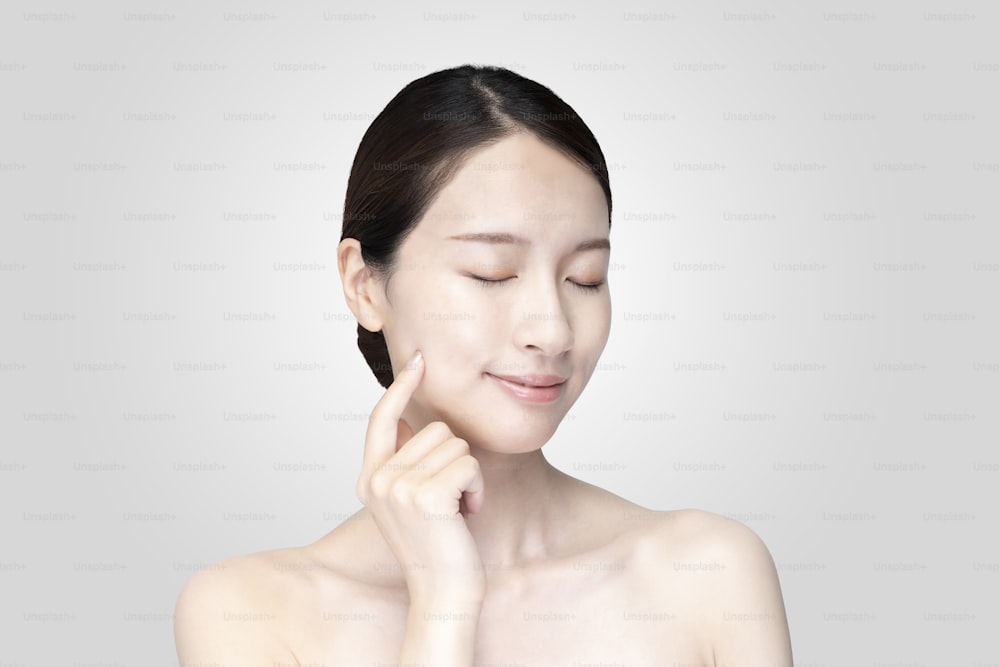 Asian young woman touching face with her hand in relaxed expression