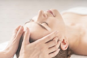 Young woman having her head massaged at the beauty salon