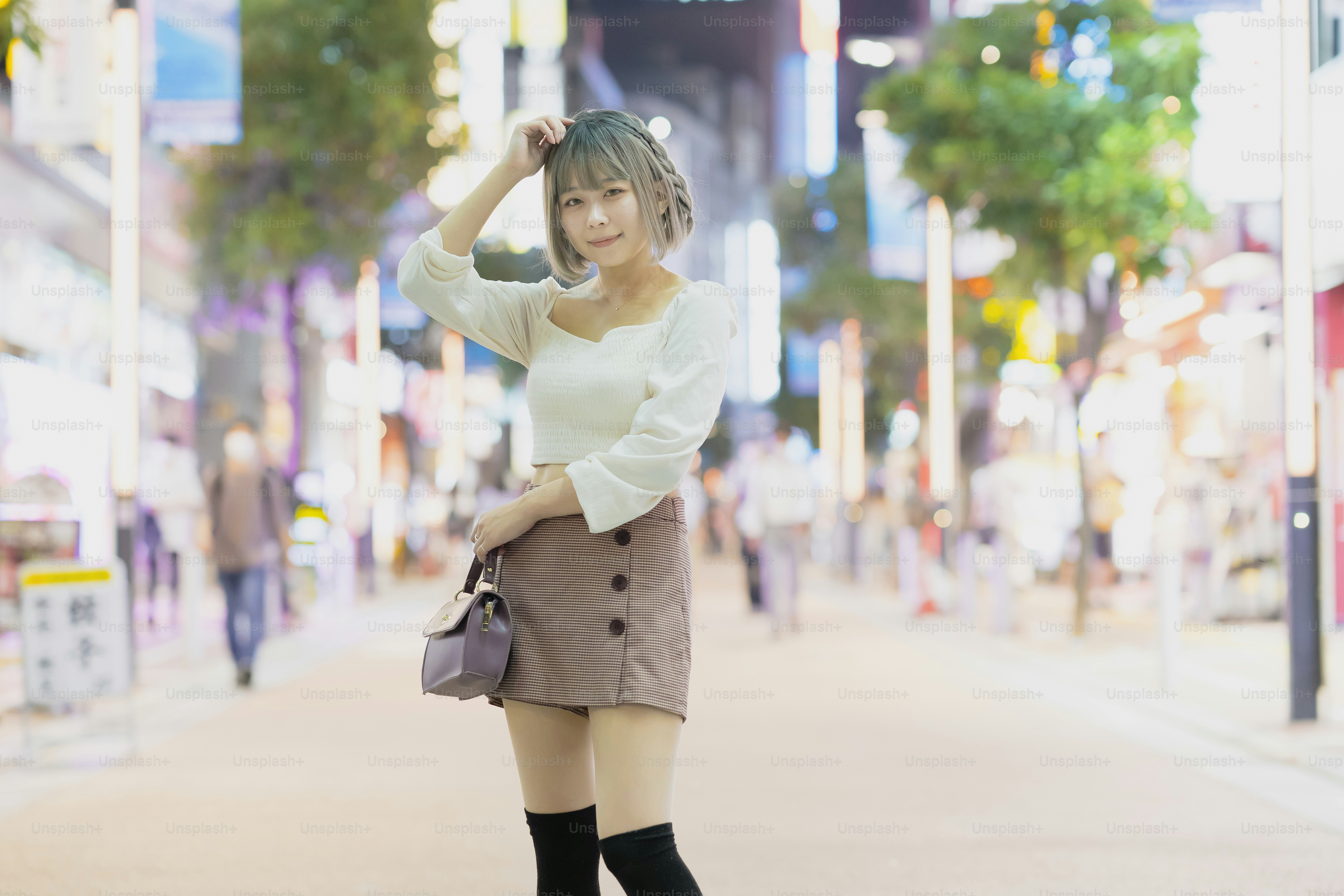 Young woman posing in the glowing cityscape of Tokyo at night