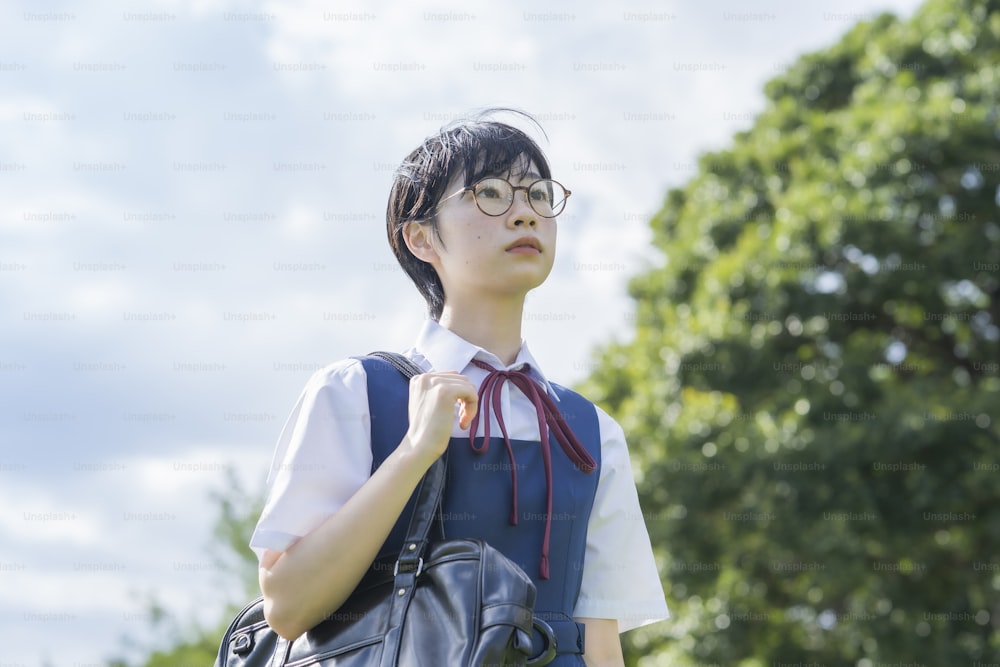 asian high school girl with glasses looking up at the sky