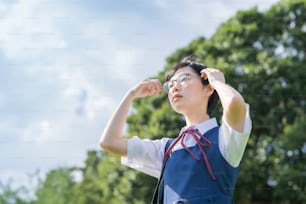 asian high school girl with glasses looking up at the sky