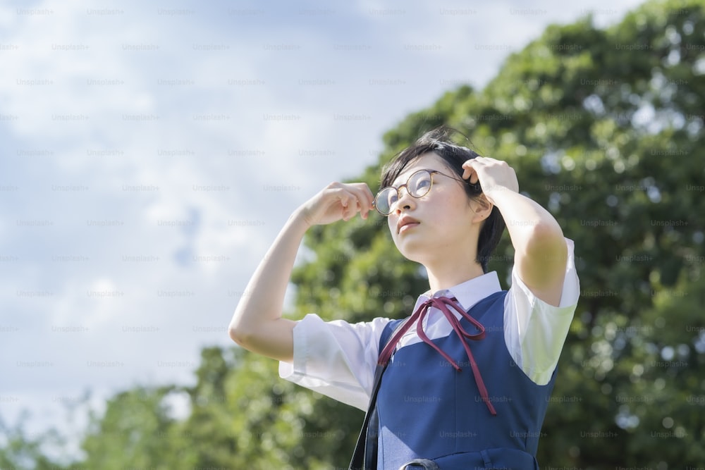 menina asiática do ensino médio com óculos olhando para o céu
