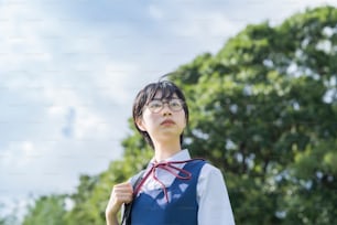 Asiatisches Highschool-Mädchen mit Brille, das in den Himmel schaut