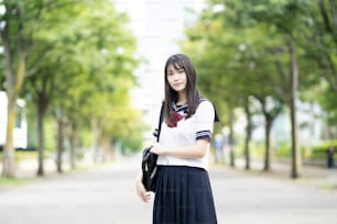 Estudante asiática do ensino médio sorrindo de uniforme ao ar livre
