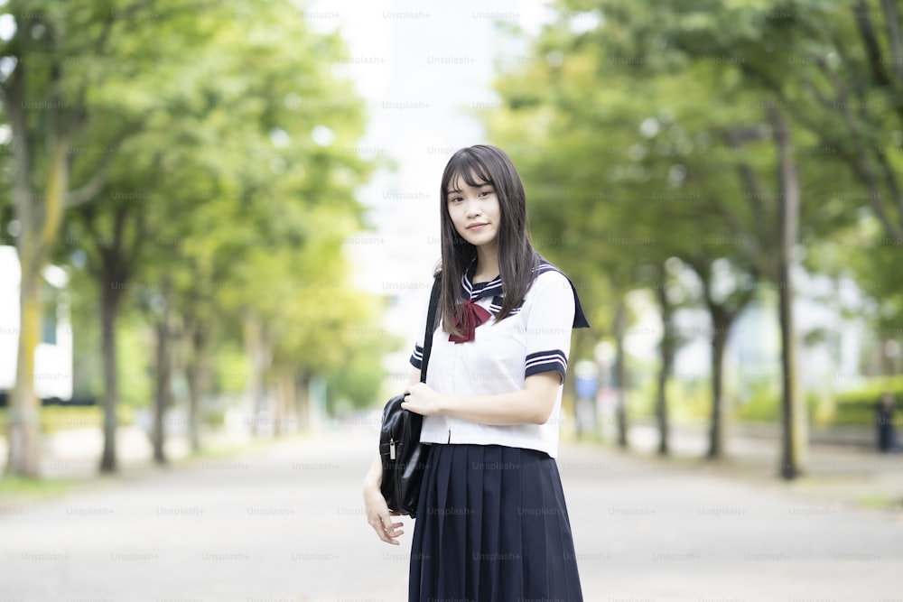 야외에서 유니폼을 입고 웃고 있는 아시아 여자 고등학생
