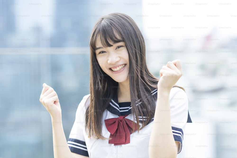 Una estudiante de secundaria posando apoyando con una sonrisa al aire libre