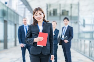 Mulher de negócios asiática smily em pé e sua equipe de negócios