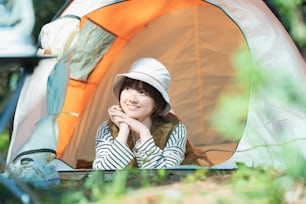 Solo camp image-A young woman lying down in a tent